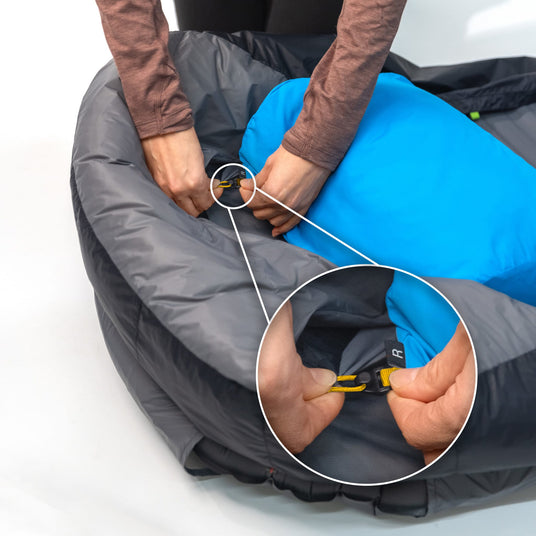 Close-up view of Zenbivy sheet's built-in headboard clips securing a Zenbivy SoftTop™ Pillow in place on a camping mattress.