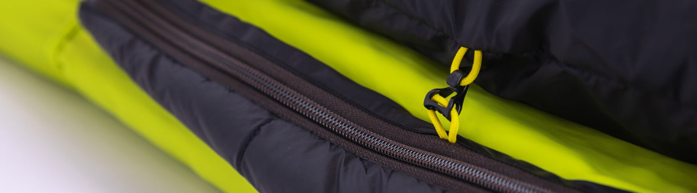 Close-up of Zenbivy's color-coded clip system and zipper on a lime green and black Universal Sheet, showing the durable materials and attachment points.