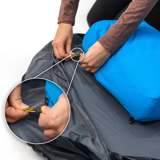 Close-up of Zenbivy headboard clips securing SoftTop pillow to integrated hood of camping sheet, preventing pillow from sliding off mattress.
