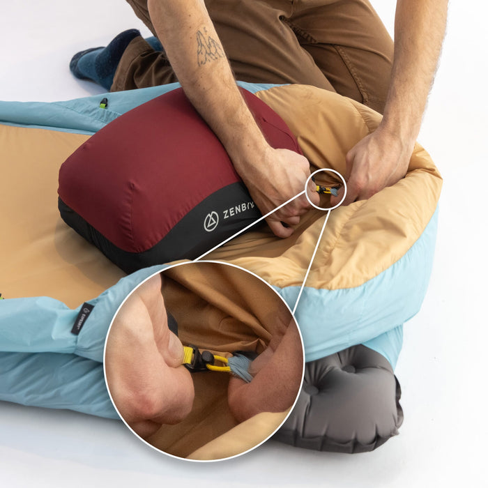 Person clipping a Zenbivy SoftTop Pillow into the sheet's hood