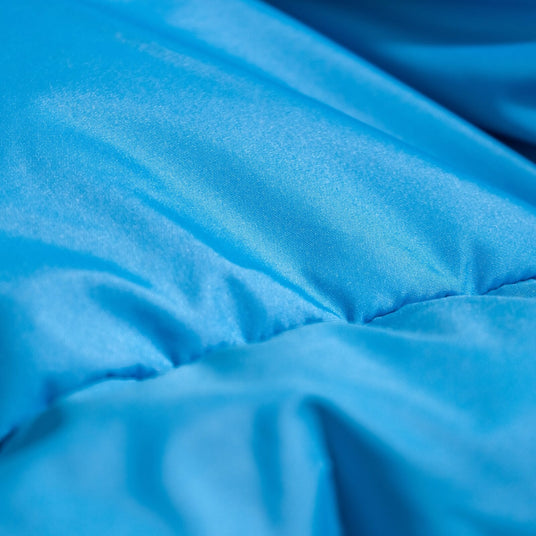 Close-up of soft, blue 50D Polyester Pongee fabric used in Zenbivy sleeping bags, highlighting its smooth, luxurious texture designed for camping comfort.