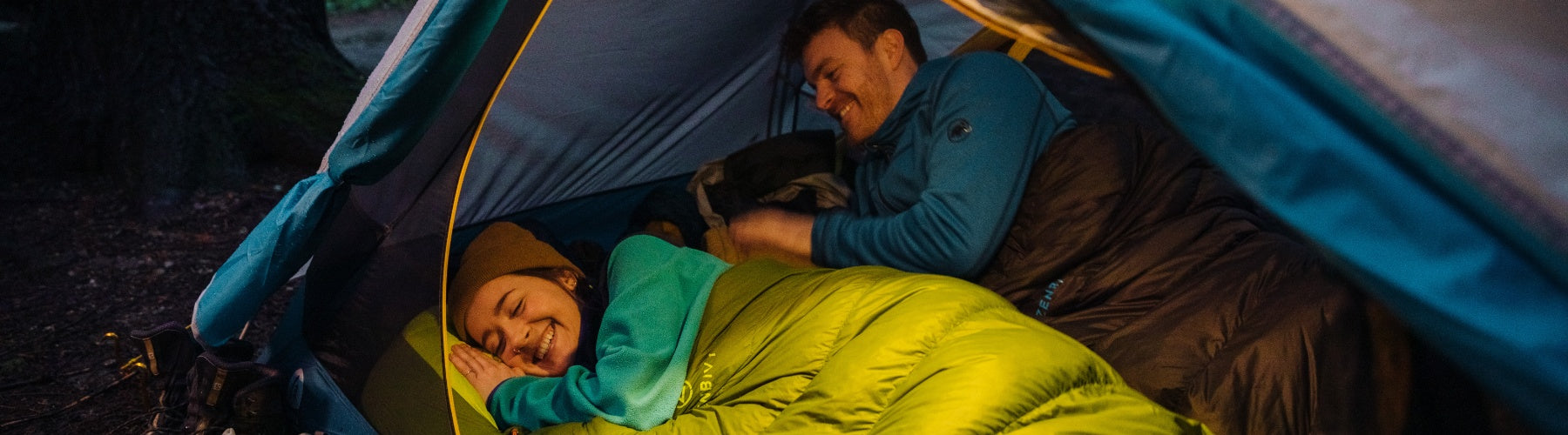 Camping couple warm in their Zenbivy sleeping bags inside their tent