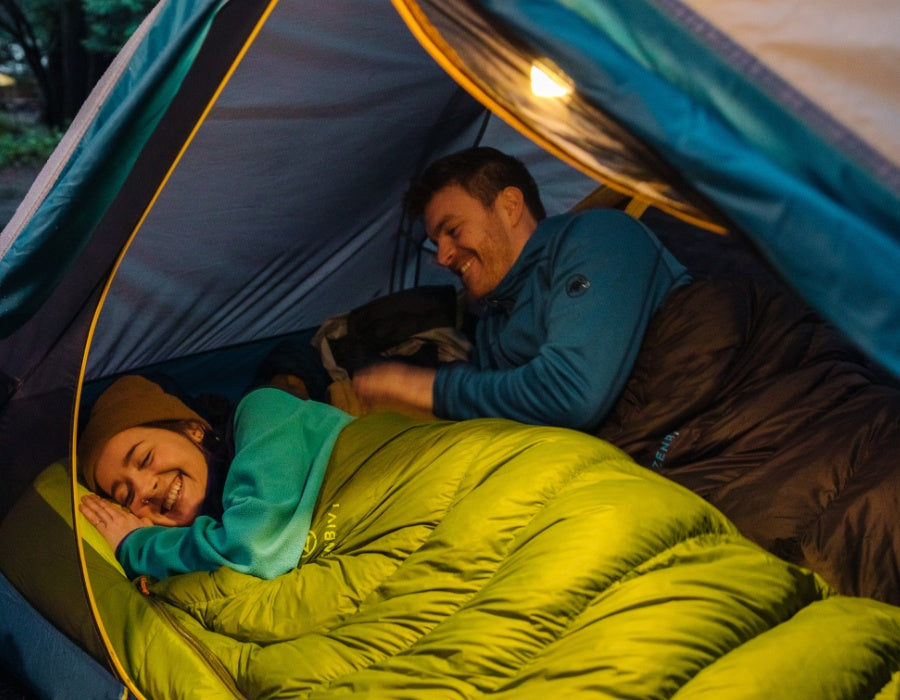 Camping couple warm in their Zenbivy sleeping bags inside their tent